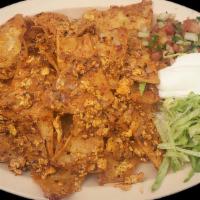 CHILAQUILES · Crispy tortilla strips stewed with eggs, beans, cheese, and sauce. Served with lettuce, sour...