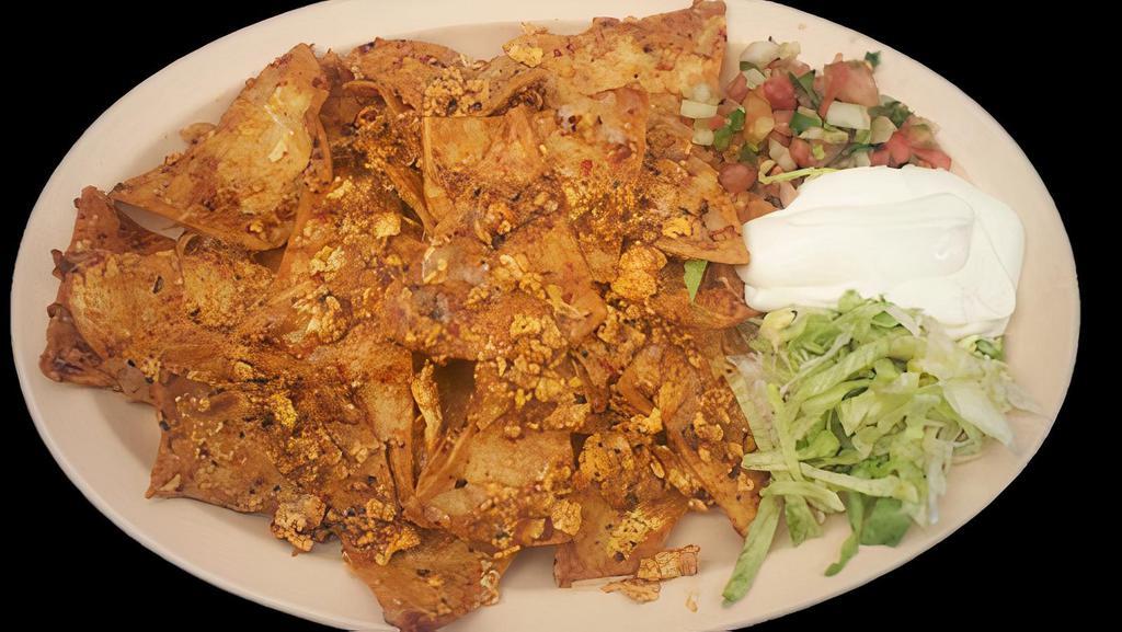 CHILAQUILES · Crispy tortilla strips stewed with eggs, beans, cheese, and sauce. Served with lettuce, sour cream, and salsa.