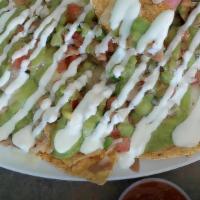 NACHOS VEGGIE · Corn tortilla chips topped with melted cheese, whole pinto beans, sour cream, guacamole and ...