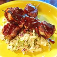 Charbroiled Bacon Shrimp Skewers · Prawns wrapped tightly in bacon, brushed with BBQ sauce, and served on a bed of coleslaw.