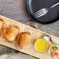 Samosa · Homemade crispy wheat rolls, stuffed with minced chicken, potatoes, and onions served with o...