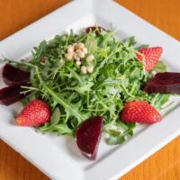 Organic Beet Salad · Served with arugula, seasonal fruit, pine nuts, lemon dressing.