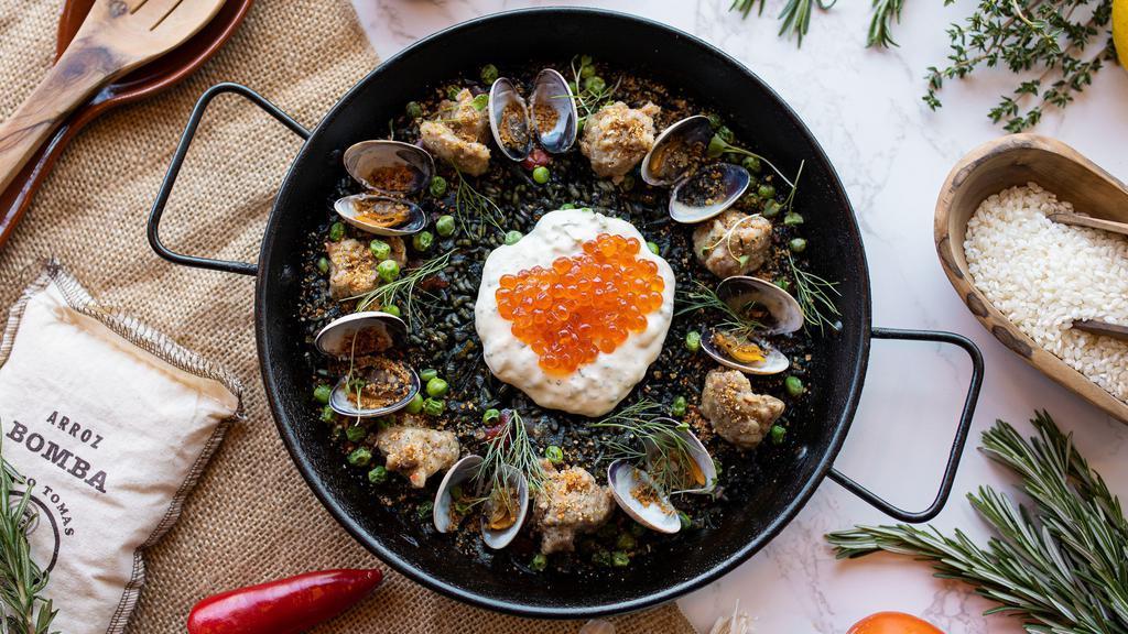 Arroz Negro · Squid ink, clams, fennel sausage, green peas, anchovy bread crumbs.