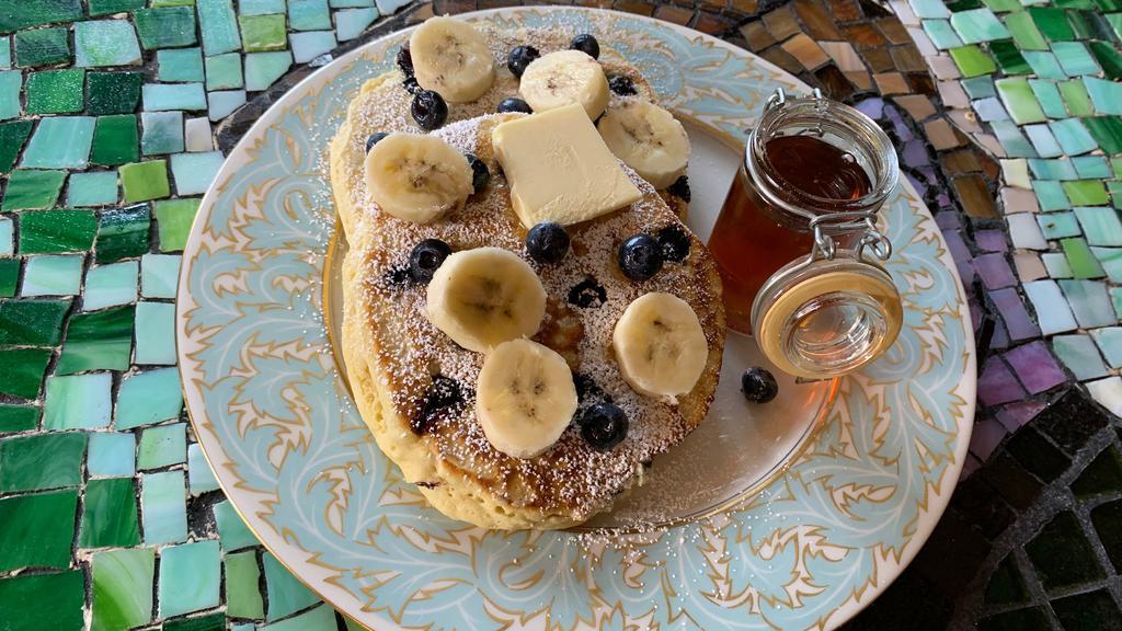 Blueberry-Banana Pancakes · 2 large buttermilk pancakes with blueberry, bananas, syrup, and butter.