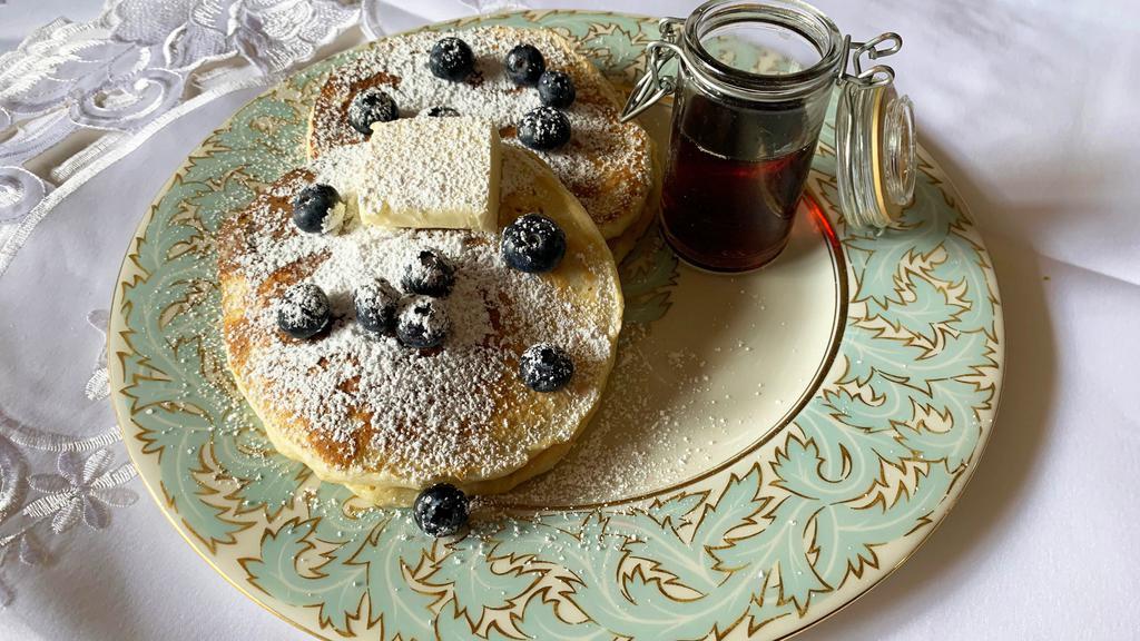 Blueberry Pancakes · 2 large buttermilk blueberry pancakes with syrup and butter.