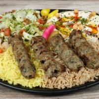 Kofta Kabob plate · 4 skewer of mix ground lamb ＆ beef over seasoned rice served with house salad, hummus and pi...