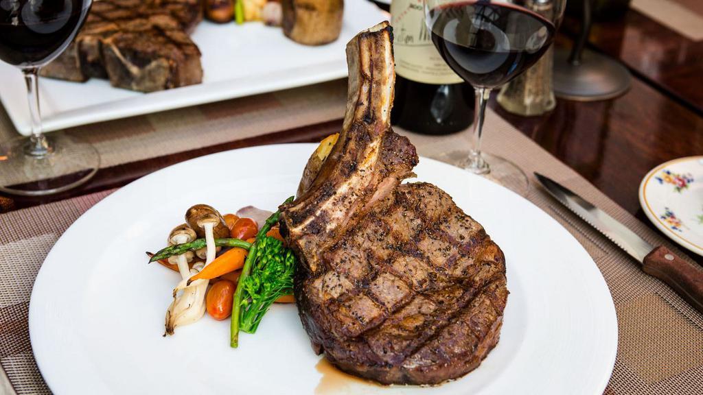 Cowboy · 18 oz dry aged bone-in ribeye, roasted cipollini and Demi glace. Served with twice baked potato & seasonal vegetables.