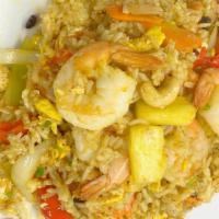 Pineapple Fried Rice · Stir fried rice with pineapple chunks, yellow onions, carrots, bell peppers, cashew and rais...