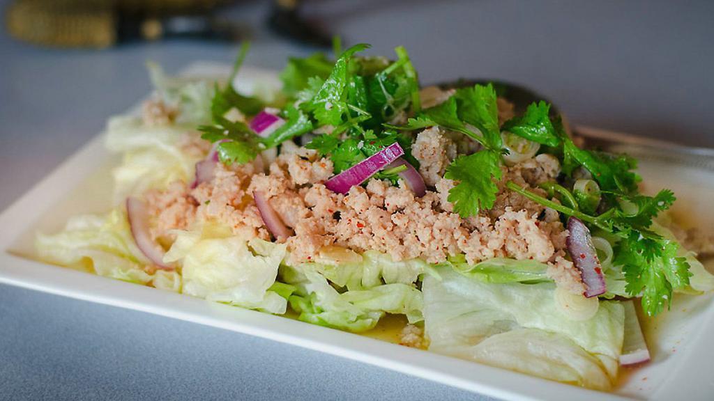 Larb Chicken · Grounded chicken toss with grounded roasted rice, chili powder, mint in chili lime dressing
