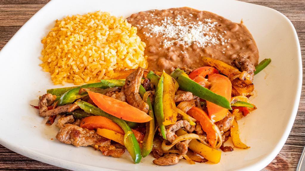 Fajitas · Marinated strips of chicken breast or steak with a complement of sautéed onions, tomatoes and bell peppers.