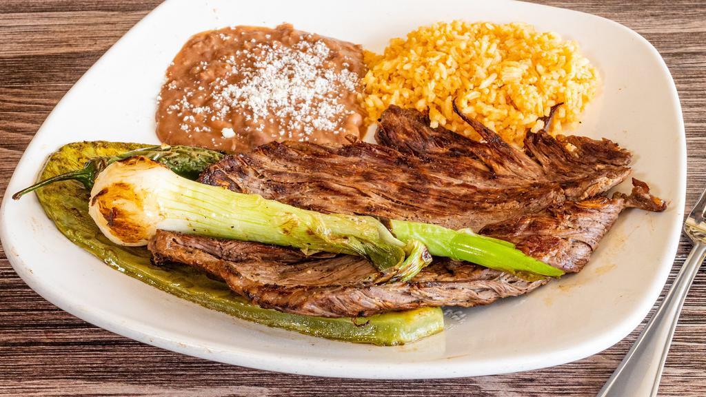 Carne Asada · Grilled carne asada topped with grilled onions and serrano peppers.