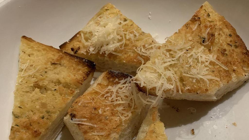 Garlic Bread · House made bread topped with a creamy butter, garlic, Parmesan cheese, and parsley spread.