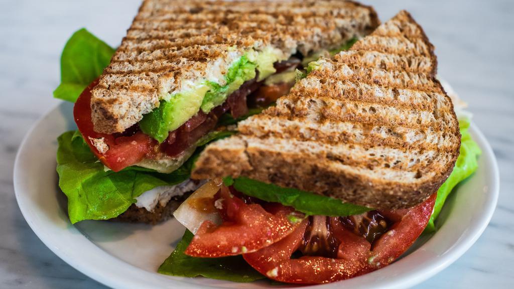 Turkey Club Sandwich · Sliced turkey, mayo, bacon, tomato, butter leaf lettuce and avocado on sliced whole grain wheat bread.
