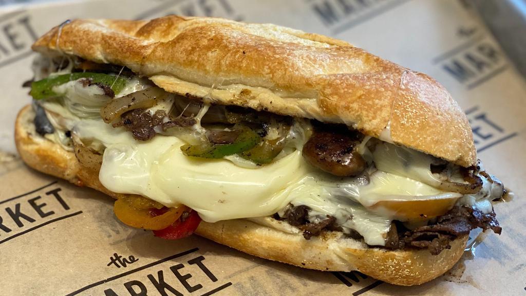 Philly Cheesesteak Sandwich · Choice of beef or chicken, caramelized onions and cherry hot peppers with provolone cheese on a soft rough.