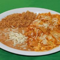 Chilaquiles · Refried beans, rice, tortilla chips sauteed with in a special sauce, eggs, cheese and sour c...