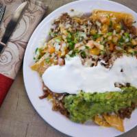Super Nachos ￼ · Corn tortilla chips topped with re-fried beans, cheese, choice of meat, sour cream, guacamol...