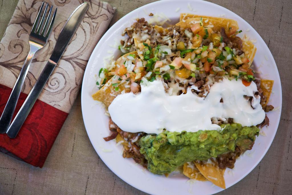 Super Nachos ￼ · Corn tortilla chips topped with re-fried beans, cheese, choice of meat, sour cream, guacamole and salsa.