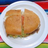 Torta Mexicana · Mexican bread, re-fried beans, cheese, guacamole, sour cream, lettuce, tomato, jalapeño pepp...