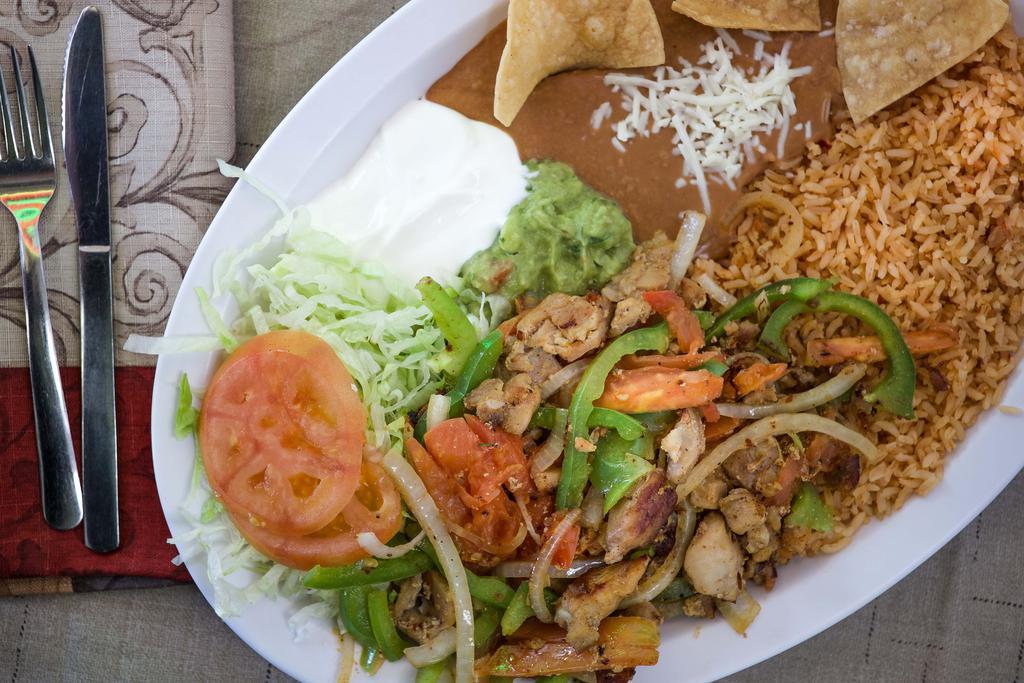 Fajitas (Beef or Chicken) · Beef or chicken sauteed with onions, tomatoes and bell peppers. Served with rice, re-fried beans, lettuce, sour cream., guacamole and tortillas.