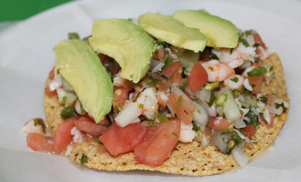 Tostada De Ceviche · Seafood. Tortilla shell with lime, crab, shrimp, onions, tomatoes, cilantro and avocado.