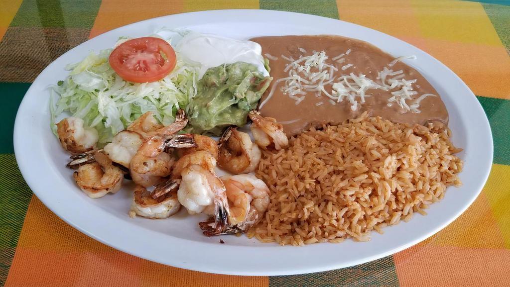 Camarones a la Plancha · Grilled shrimp with refried beans, rice, lettuce, guacamole, sour cream, cheese and tortillas.