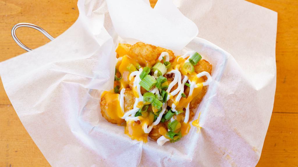 Tot-Chos · Crispy tater-tots with melted cheese, bacon, sour cream, and green onion.
