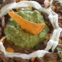Supremo Nachos · Chips, refried beans, cheese, meat, guacamole, sour cream, and pico.