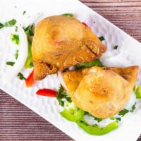 Samosa · Two pieces. Veggie turnover, stuffed with potatoes, green peas, herbs and spices, served wit...
