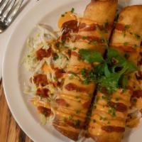 Lobster Taquitos (2 Pc) · Drizzled with awesome sauce, flour tortilla, guacamole.