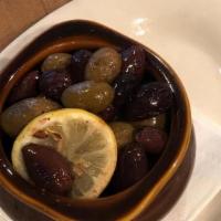 Mediterranean Olives · Marinated mixed whole olives warmed with lemon in our wood-fired brick oven.