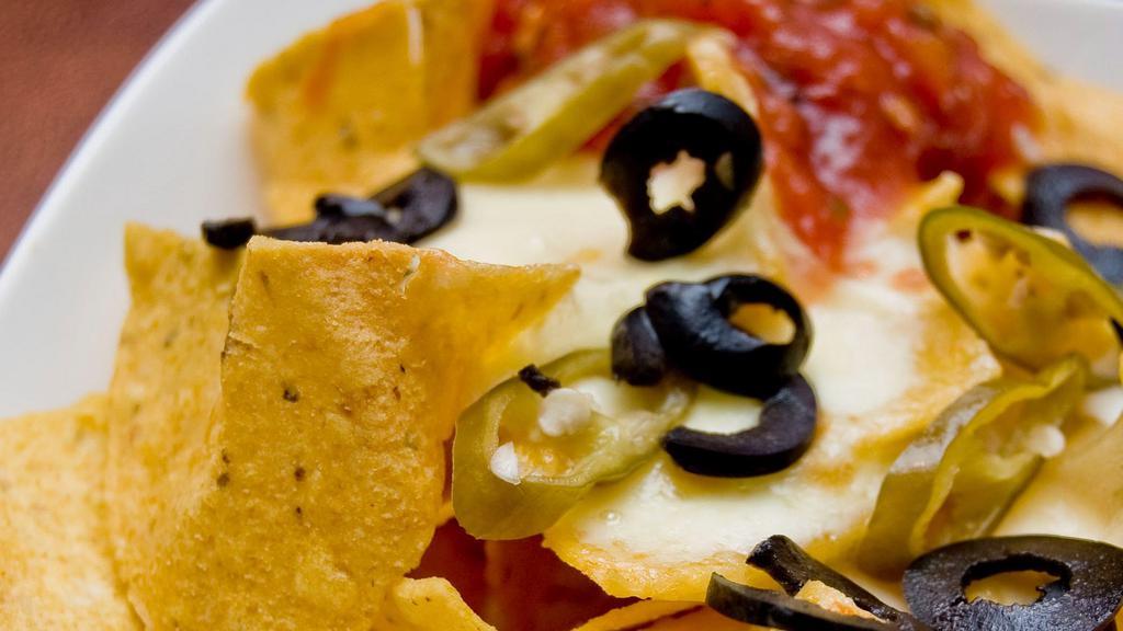 Nachos · Crisp corn tortilla chips piled high and smothered with a blend of melted cheese, your choice of topping and garnished with diced tomatoes and green onion. Cheese add shredded chicken, ground beef, shredded beef or chorizo (sausage) and fresh guacamole for additional charges.