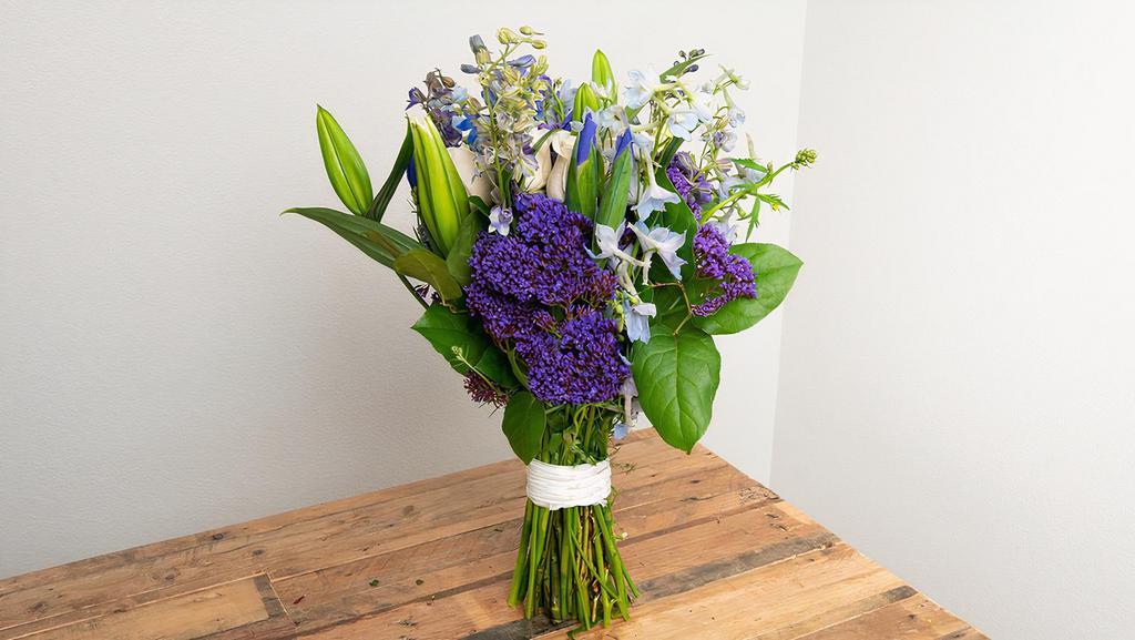 White, Blue, Purple Wrapped Bouquet · Seasonal options may vary throughout the year and depending on location. Our florist will provide the best available flowers for your order!