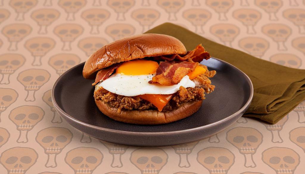 Breakfast Fried Chicken Sandwich · Crispy fried chicken breast with crispy bacon, melted cheddar cheese, and a fried egg on a buttery brioche bun.