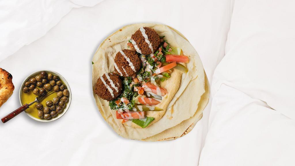 Free-Falling Falafel Wrap · Ground chickpeas, onions, garlic, and parsley blended with Mediterranean spices, then formed into patties and deep fried in vegetable oil.