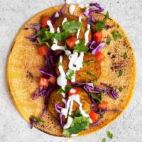 Falafel Taco · Crispy falafel with shredded cabbage, tomatoes, tzatziki, and cilantro in a flour tortilla.