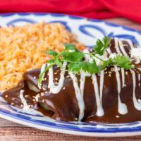 Chicken Enmoladas · Filled with chicken, rolled in mole rojo, topped with sour cream, queso fresco and toasted s...