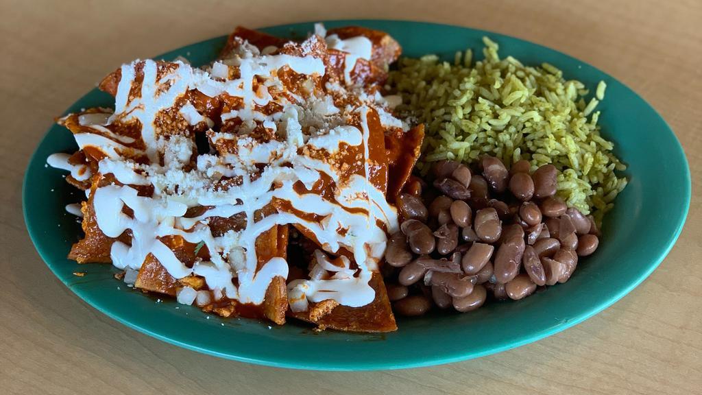 Chilaquiles Rojo · Sliced corn crispy tortillas, mixed with egg and cooked in a traditional red sauce topped with onions. Served with rice and beans.