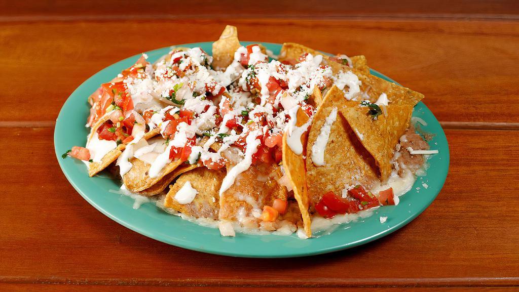 Cheese Nachos · Homemade chips topped with Cheese, guacamole, sour cream, salsa fresca and your choice of beans.
