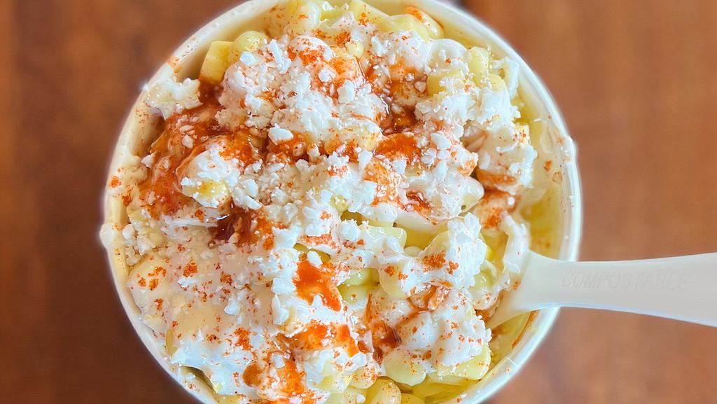 Esquites (Street Corn) · White corn mixed in a creamy epazote sauce and lime, topped with Mexican dried chile powder, hot sauce and Mexican cheese.