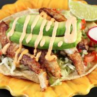 Seafood Taco · Grilled fresh fish or shrimp marinated in garlic, served on a corn tortilla topped with lett...