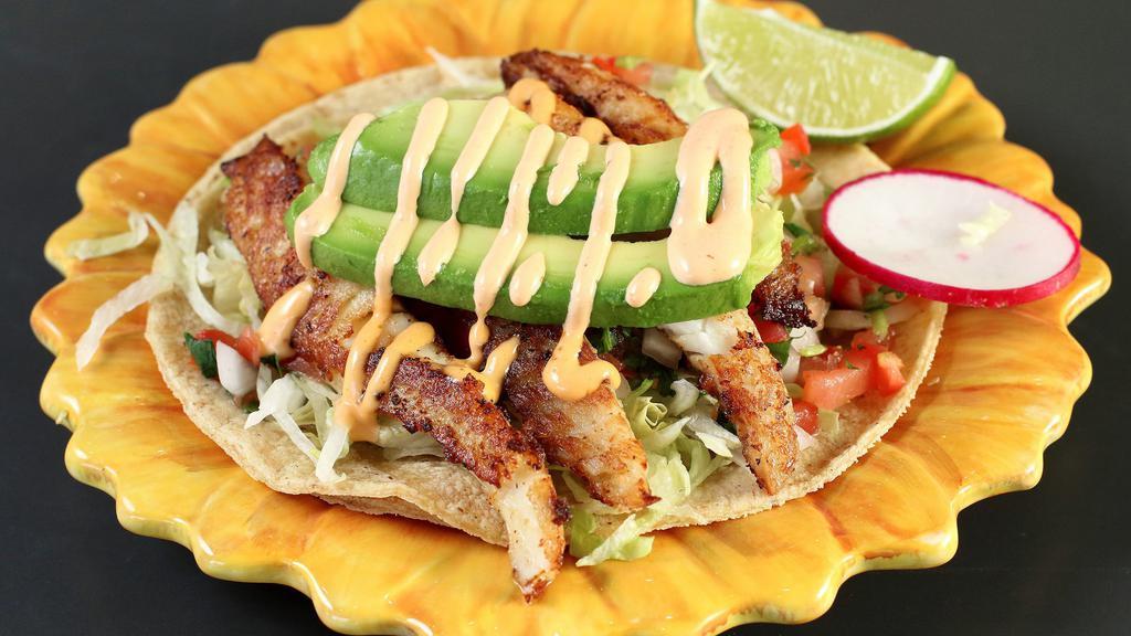Seafood Taco · Grilled fresh fish or shrimp marinated in garlic, served on a corn tortilla topped with lettuce, salsa fresca, sliced avocado and a spicy chipotle sauce.