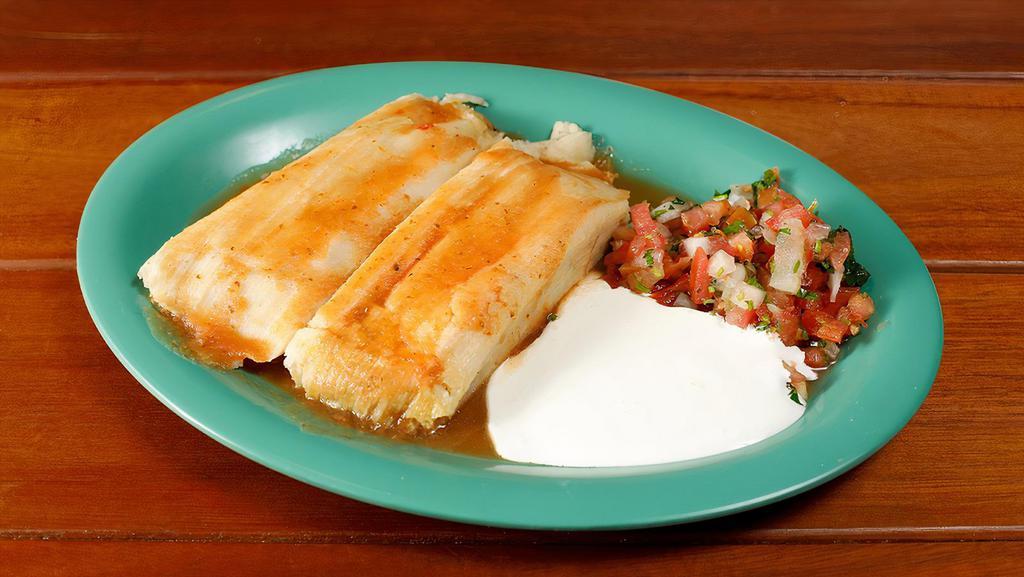 Tamales (2) · Two homemade tamales with your choice of chicken, pork or poblano pepper and cheese, served with tomato sauce, sour cream, and salsa fresca.