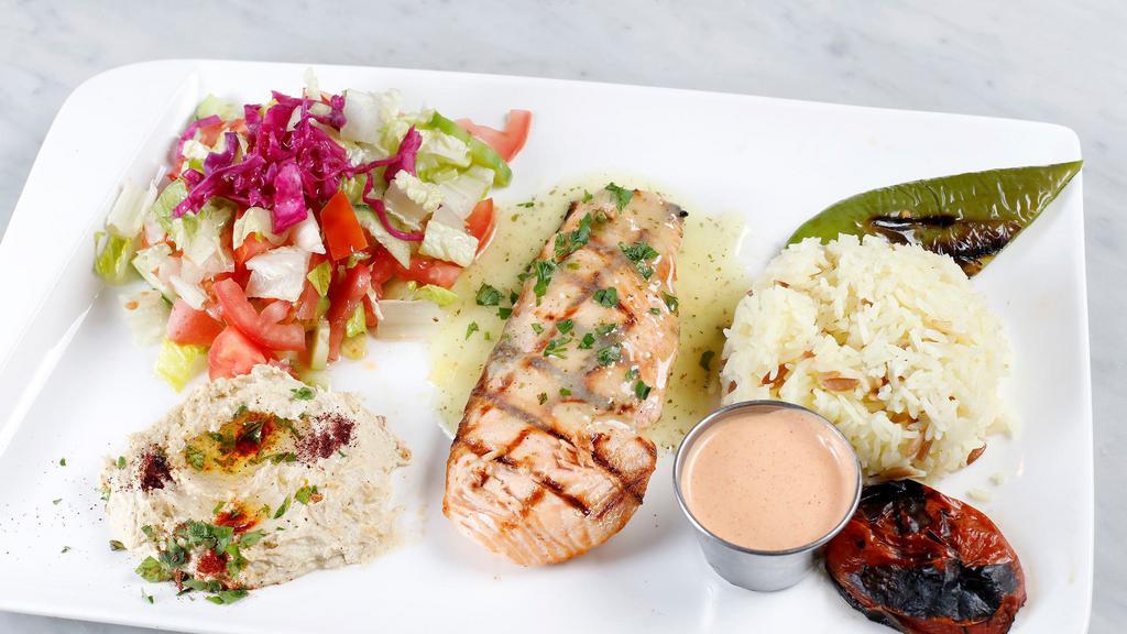 Salmon Plate · Slow cooked marinated salmon on grill. Served with rice, salad, and pita bread.