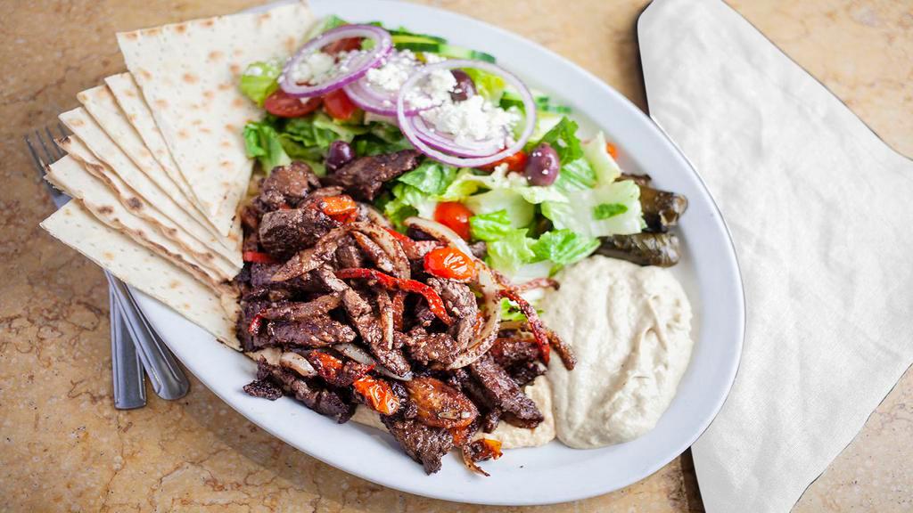 Shalaby Steak · Strips of flank steak seasoned with Mediterranean spices, bell peppers, cherry tomatoes and onions over our yummy hummus with baba ghanouj, dolmas, Greek salad and lavash bread.