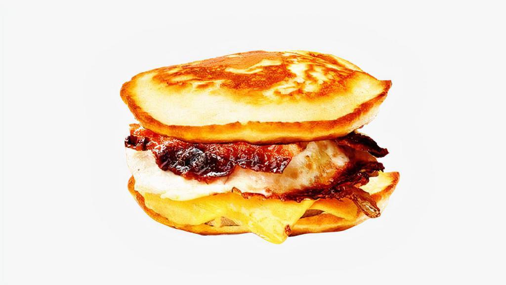 Bacon, Egg, and Cheese Pancake Sandwich · Bacon, scrambled egg, and cheddar cheese between two pancakes and served with syrup on the side.