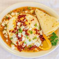 Huevos Rancheros · Two corn tortillas, refried beans, homemade salsa, jack and cheddar cheese, and chorizo. Top...
