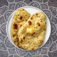 Garlic Cheese Naan · Freshly baked bread in a clay oven garnished with garlic and cheese.