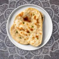 Sweet Naan · Freshly baked bread in a clay oven garnished with sugar, coconut, and raisins.