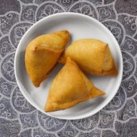 Lamb Samosa · Two crispy puffs filled with ground lamb, onions, and herbs.