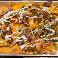 LOADED NACHOS · Tortilla chips, house made nacho cheese, pico, pickled jalapeños, spicy avocado crema and yo...
